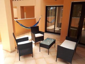 卢斯Rother Praia da Luz Luxury Apartment的一个带椅子和吊床的阳台。