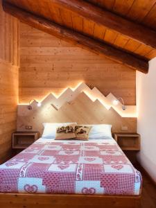科尔蒂纳丹佩佐白塔弗莱那住宿加早餐旅馆的木制客房内的一间卧室,配有一张床