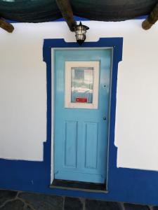 雷根古什-迪蒙萨拉什Casa da Eira的白色墙壁上的一扇蓝色门,上面有灯