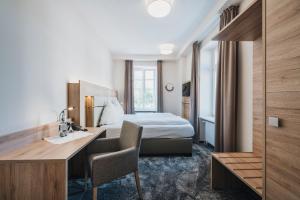 梅尔齐希罗默酒店餐厅的配有一张床和一张书桌的酒店客房