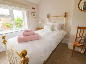 奥克姆Bennett's Cottage的一间卧室配有一张床,床上铺有粉红色的毛巾
