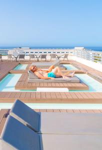 美洲海滩Coral Suites & Spa - Adults Only的躺在游轮甲板上的女人