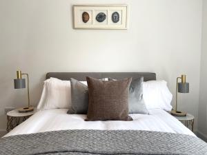 珀斯High Street Stylish City Centre Apartment, 2 Bed的一间卧室配有一张带枕头的床和两盏灯。