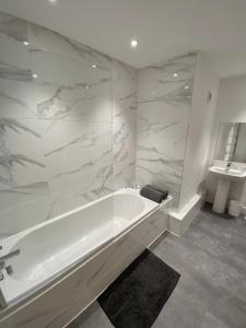 珀斯High Street Stylish City Centre Apartment, 2 Bed的白色的浴室设有浴缸和水槽。