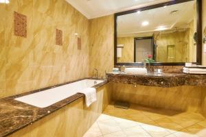 阿吉曼巴希阿治曼宫酒店 的一间带浴缸和大镜子的浴室