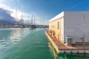 朱利亚诺瓦AQUA RESORT GIULIANOVA - Houseboat Experience的码头上建有楼房和船只的码头