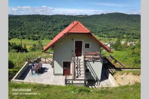 Žužemberkvakantiehuis Zidanica的山丘上一座带红色屋顶的小房子