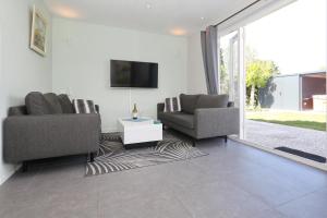 诺德韦克Paleisje Noordwijk的客厅配有两把椅子和电视