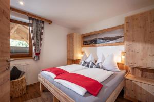 齐勒河谷采尔Haus Gatterland的一间卧室配有一张铺有白色和红色床单的床
