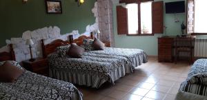 乌鲁埃尼亚Pozolico Hotel Rural的一间卧室配有两张床、一张桌子和一把椅子