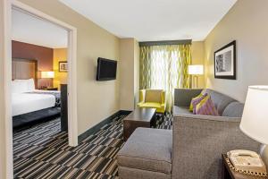 斯普林La Quinta Inn & Suites by Wyndham The Woodlands Spring的酒店客房设有一张沙发和一张床
