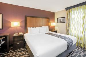 斯普林La Quinta Inn & Suites by Wyndham The Woodlands Spring的酒店客房设有一张大床和一张书桌。