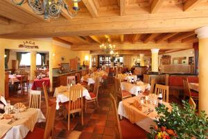 萨尔巴赫Unterwirt的餐厅设有白色的桌椅和木制天花板。
