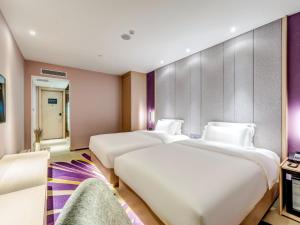 天津Lavande Hotel Tianjin Joy City Gulou Subway Station的酒店客房,设有三张床和一张沙发