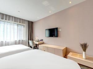 天津Lavande Hotel Tianjin Joy City Gulou Subway Station的酒店客房设有一张床、一张书桌和一台电视机。