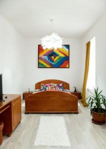 布勒伊拉Pensiunea Lms的卧室配有一张床,墙上挂有绘画作品
