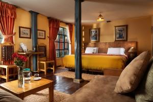 MachachiHacienda El Porvenir by Tierra del Volcan的一间卧室配有黄色的床和沙发