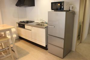 北谷町Hotel Flap Resort的厨房配有白色冰箱和水槽