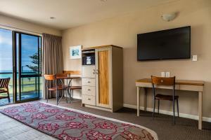 纳皮尔卵石海滩汽车酒店的酒店的客房配备了书桌和平面电视。