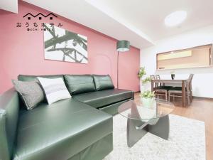 广岛OUCHI HOTEL Itsukaichi的客厅配有绿色沙发和桌子