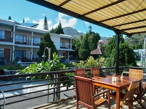 塔旺曼谷Hotel Pondok Asri Tawangmangu的阳台上的木桌和椅子