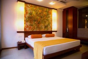 康提黄宝石酒店的一间卧室配有一张壁画床