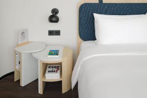 台北杰仕堡有氧酒店的一间卧室配有一张床、一张桌子和一张四柱床。