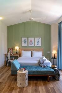 大叻La Em Boutique Villa的一间卧室配有一张大床和蓝色长凳