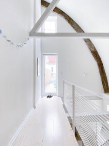 弗伦斯堡Ferienhaus Grosse 73, Flensburg的拥有白色墙壁的走廊和设有窗户的楼梯