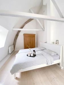 弗伦斯堡Ferienhaus Grosse 73, Flensburg的一间白色的卧室,配有一张带托盘的床