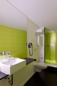 柏林加特点查理酒店的绿色浴室设有水槽和卫生间