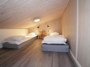 耶尔夫瑟Stuga i Järvsöbacken的小型客房设有两张带木制天花板的床。