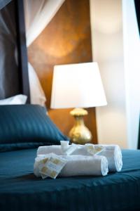 菲乌米奇诺Le Boutique Luxury Rooms的床上的折叠毛巾,带灯