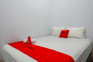 兰特包RedDoorz At Rantepao Toraja Utara的一张白色的床,上面有红毯