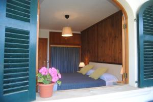 索列尔Alojamiento Tramuntana - Apartaments tres Vents的一间卧室配有一张床和盆栽植物