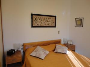 夸尔图-圣埃莱娜Fede & Francy的一张带两个枕头的床和一张墙上的照片