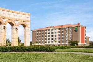 迈尔斯堡Holiday Inn Express Hotel & Suites Fort Myers East - The Forum, an IHG Hotel的一座大型建筑,有两座大柱子和一座建筑