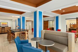 迈尔斯堡Holiday Inn Express Hotel & Suites Fort Myers East - The Forum, an IHG Hotel的大堂配有沙发和桌椅