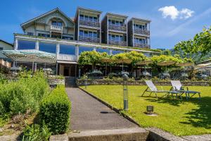 图恩Schönbühl Hotel & Restaurant Lake Thun的一座大建筑前面设有两把草坪椅