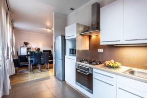卡罗维发利利兹登斯瑟托卡酒店的厨房配有白色橱柜和炉灶烤箱。