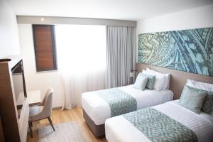 阿皮亚Lava Hotel的酒店客房配有两张床和一张书桌