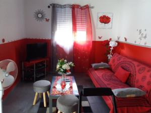 拉芒坦Villa Bananier的红色的客厅配有红色的沙发和桌子