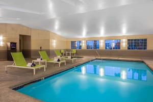 拉斯维加斯La Quinta Inn & Suites by Wyndham Las Vegas Nellis的游泳池位于酒店客房,设有绿色椅子和游泳池