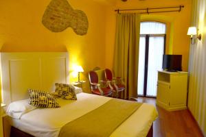 莱昂Hotel Alda Vía León的一间卧室设有一张黄色墙壁和窗户的床
