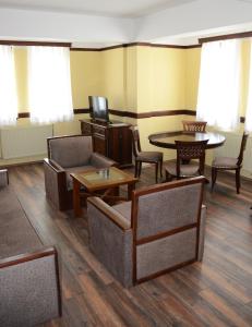Ljubaništa圣瑙姆酒店的一间设有桌椅和电视的等候室