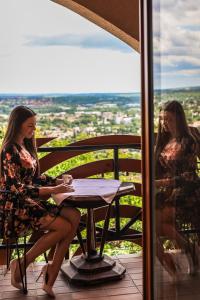 佩奇Bagolyvár Panzió的两名妇女坐在阳台上的桌子上