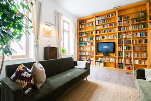 莱比锡theleaf - design apartment & café的客厅配有绿色沙发和书架