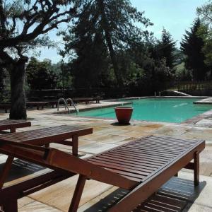科斯蒂廖莱萨卢佐罗索城堡酒店的坐在游泳池前的木凳