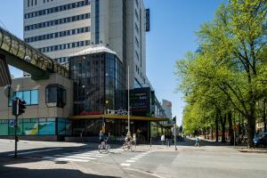 瓦萨Omena Hotel Vaasa Espen的两个人骑着自行车沿着城市的街道骑着