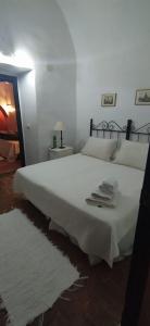 查兹拉德拉谢拉La Cartuja de Cazalla的卧室配有带毛巾的大型白色床
